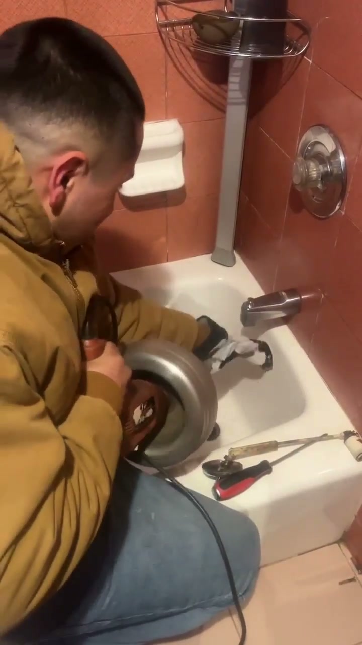 Daniel clearing a bathtub drain